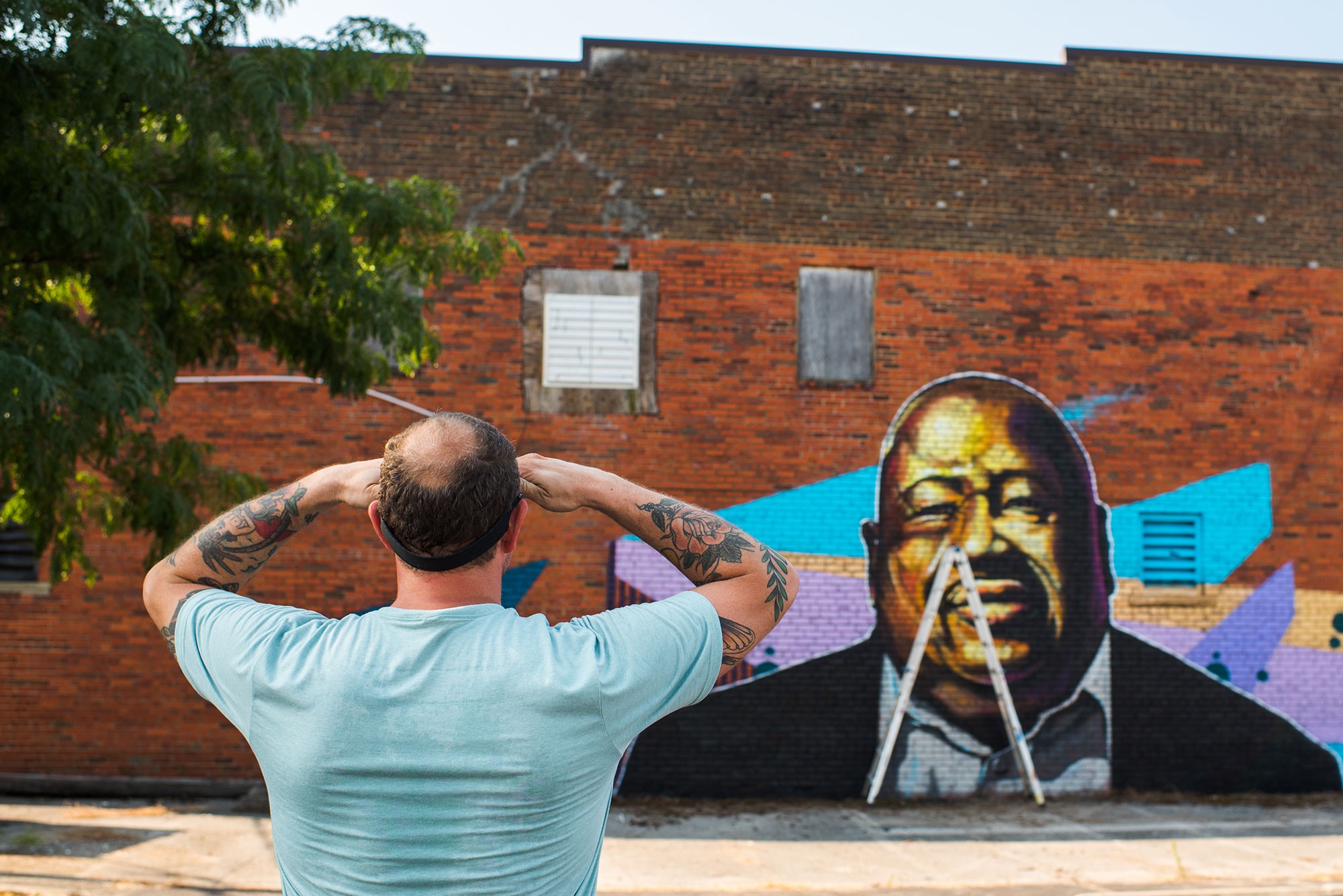 man looks at painting on wall