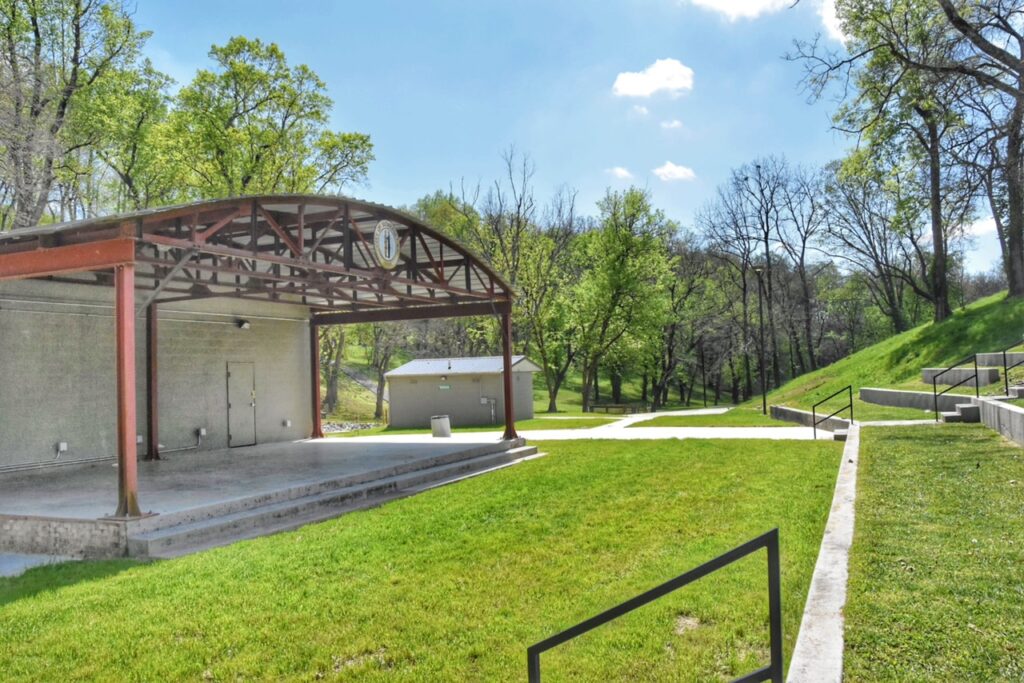 grassy amphitheater in park with a covered stage